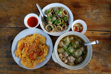 Thai set menu with tomato omelette, boiled pork, fried squid cooked with black pepper.