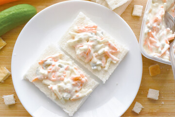 Creamy coleslaw sandwich on a white plate. Food from above. Flat lay top view photo.