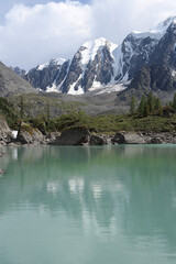 Beautiful landscape of Altay region, Siberia, Russia. Alpine valley in Altay with ridges and snow-capped peaks, the slopes are covered with dense forest