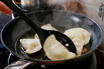 Traditional dumplings on a frying pan in the kitchen.
