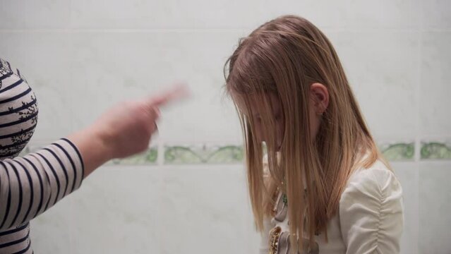 Mom punishes soy guilty daughter who bowed her head guiltily. Emotions in raising children.