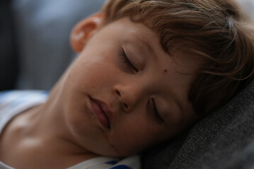 Fototapeta na wymiar Little boy sleeping on couch child asleep napping 