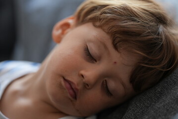 Fototapeta na wymiar Little boy sleeping on couch child asleep napping 