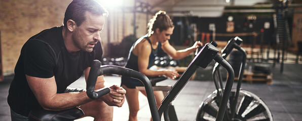 Young muscular sportspeople training on simulators