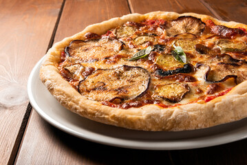 Pizza vegetariana con melanzane, zucchine e funghi su tavolo in legno 