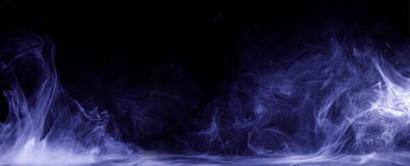 Abstract colored smoke moves on black background. Mystical swirling smoke rolling low across the ground.