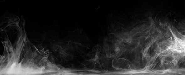 Abstract colored smoke moves on black background. Mystical swirling smoke rolling low across the ground.