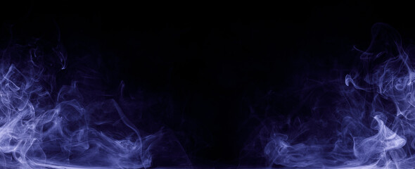 Abstract colored smoke moves on black background. Mystical swirling smoke rolling low across the ground.