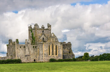 Fototapeta na wymiar Cistercian Monastery Dunbrody Abbey on green meadow against cloudy sky, County Wexford, Ireland