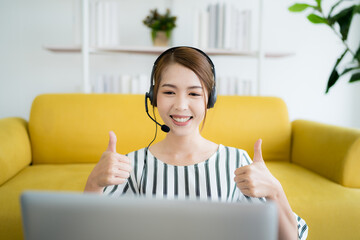 asian business woman work at home be a call center Talking to customers who call in via laptop...