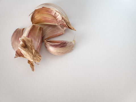 top view of garlic cloves , unpeeled, on a white background
