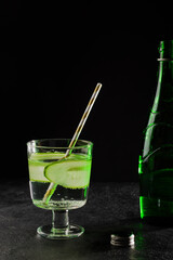 Delicious refreshing drink with cucumber and mineral water in a glass on a dark background. Detox water for diet healthy eating and weight loss.