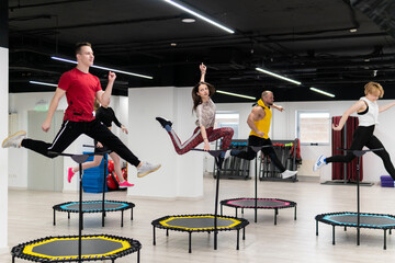 Women's and men's group on a sports trampoline, fitness training, healthy life - a concept trampoline group batut instructor men, In the afternoon fit athletic in training from exercise shaping