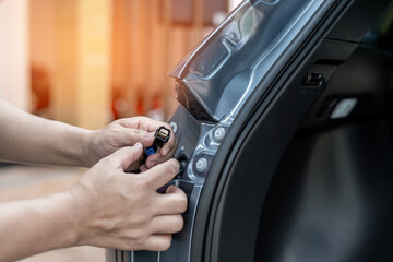 Close up hand a man hold plug of car tail lights Check for regularities and accuracy before assembling : Car electric maintenance work concept