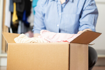 box with clothes, moving, a woman collects and packs things for moving to a new house