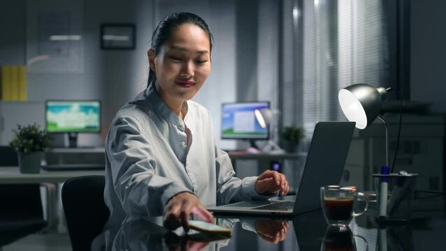 Asian businesswoman receive good news in email and smile working in office