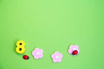 Pink flowers and an eight on a green background, a place for text.Spring