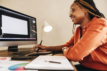 Cheerful female designer working at her desk