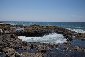 Fototapeta na wymiar waves crashing on rocks in the pacific ocean coast line
