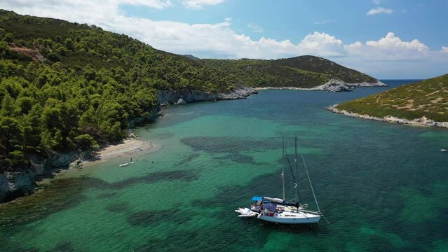 Aerial drone video of famous bay and small traditional village of Atsitsa covered in pine trees and natural sandy beaches, Skyros island, Sporades, Greece