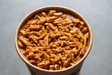 Bucket container of coffee almond ice cream with full almond on top isolated on gray background.