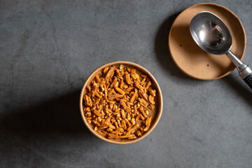 Bucket container of coffee almond ice cream with full almond on top isolated on gray background.