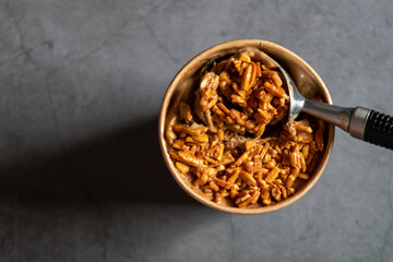 Bucket container of coffee almond ice cream with full almond on top isolated on gray background.