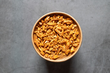 Bucket container of coffee almond ice cream with full almond on top isolated on gray background.