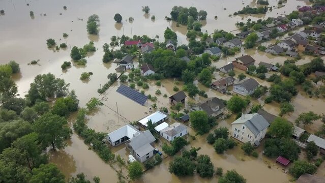 GALYCH, UKRAINE - JUNE 24, 2020: Flooded neighborhood street. Major flooding leaves city, underwater, entire community. Homes, houses overflowing water, insurance needed. Rescue teams helping people