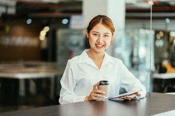 Plakat Beautiful cute asian young businesswoman in the cafe, using mobi