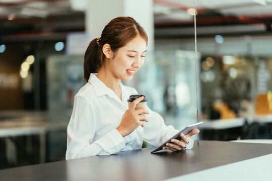 Beautiful cute asian young businesswoman in the cafe, using mobi