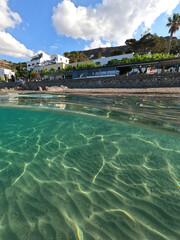 Underwater split photo taken from beautiful emerald bay and beach of Kapsali and famous Monastery of Saint John at the background, Kythira island, Ionian, Greece