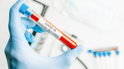 Omicron mutation coronavirus variant. Medical laboratory doctor holding test tube in hospital...