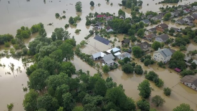 GALYCH, UKRAINE - JUNE 24, 2020: Flooded neighborhood street. Major flooding leaves city, underwater, entire community. Homes, houses overflowing water, insurance needed. Rescue teams helping people