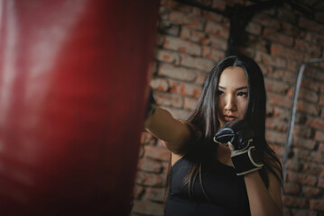 Obraz premium A girl fighter is punching a boxing bag close up concept.