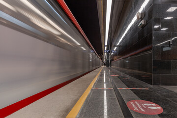Blurred subway train moving fast along subway station platform in minimalist design, Moscow, Russia