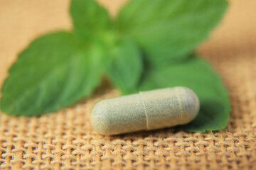 Fototapeta na wymiar close up photo of herbal capsule from organic herb for health care using. alternative multivitamins for good living life healthy eating. selective focus.