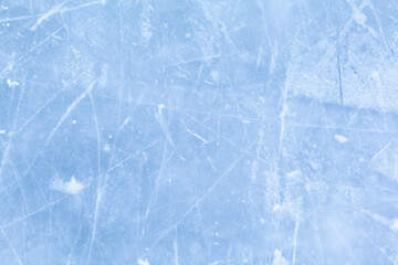 Empty ice rink with skate marks after the session outdoor. skating ice rink texture covered with snow in daylight. Close up of blue ice rink floor, copy space