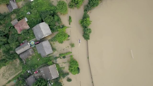 GALYCH, UKRAINE - JUNE 24, 2020: Flooded neighborhood street. Major flooding leaves city, underwater, entire community. Homes, houses overflowing water, insurance needed. Rescue teams helping people