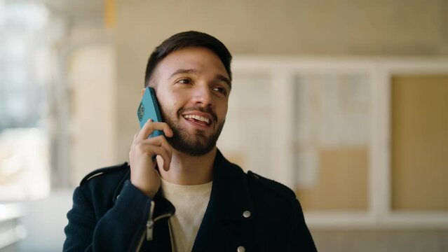 Young hispanic man smiling confident talking on the smartphone at street
