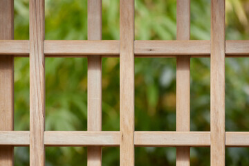 A close-up of a wooden gate with a dark green background