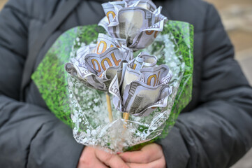 A woman is holding a bouquet of hundred-dollar bills.