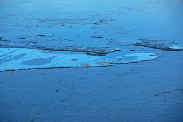 Winter nature background with blocks of ice on frozen water in spring. Abstract background of drifting ice on water © Nataliia
