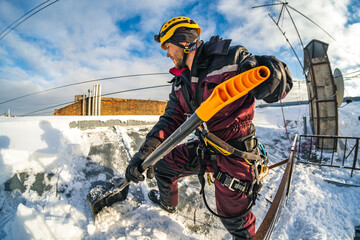 Worker cleans snow on the roof