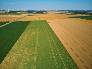 aerial drone view of wind trubines and green and yellow fields in Normandy, France
