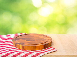 Chopping board on table cloth and blur green bokeh background.