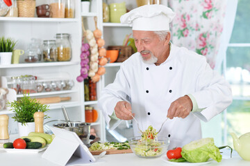 Senior man preparing dinner in kitchen