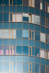 Teal and orange building in the city. Blue glass. Front view