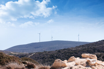 Wind turbines stand on top of a mountain