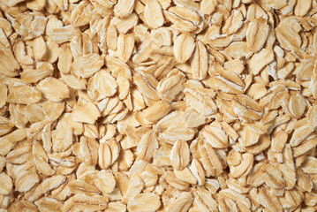 Rolled oat flakes background. Overhead view macro photo with shallow depth of field.